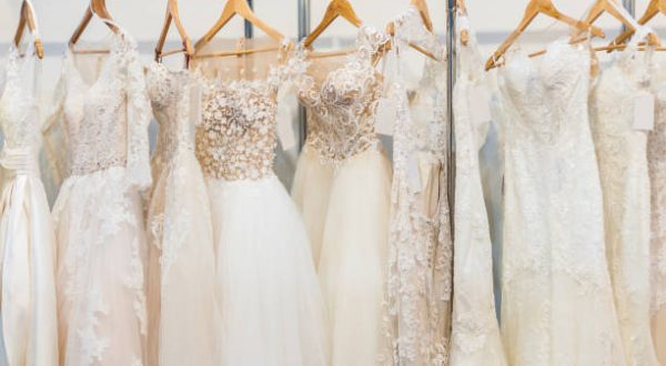 Many beautiful wedding dresses hang in the store
